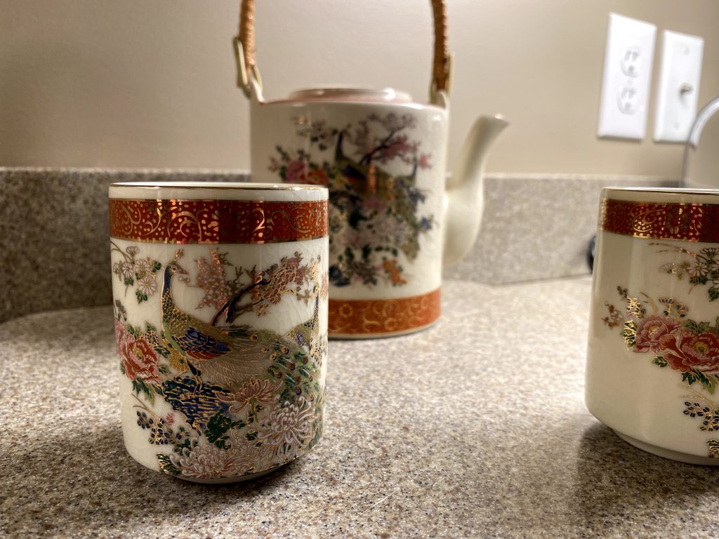 A picture of a tea set with a peacock motif