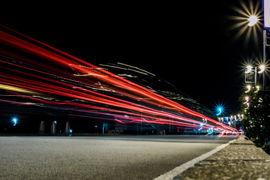 A picture of lights trails streaming down a highway, indicating speed.